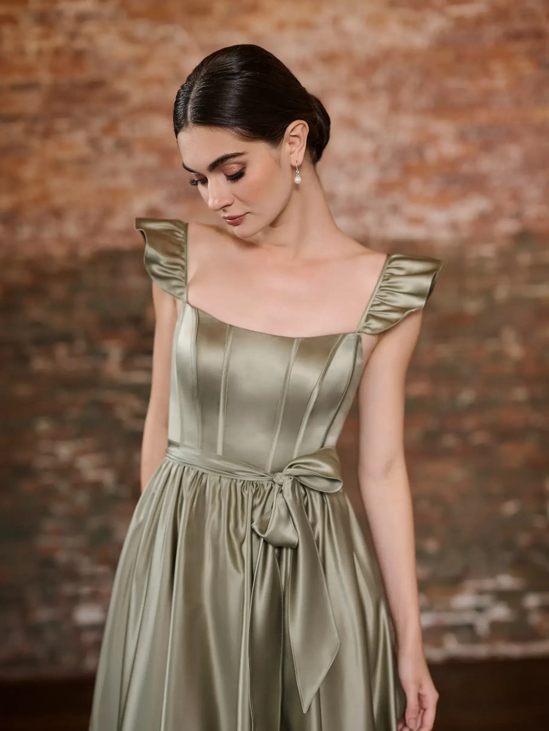 model is wearing a sage green a-line bridesmaid dress