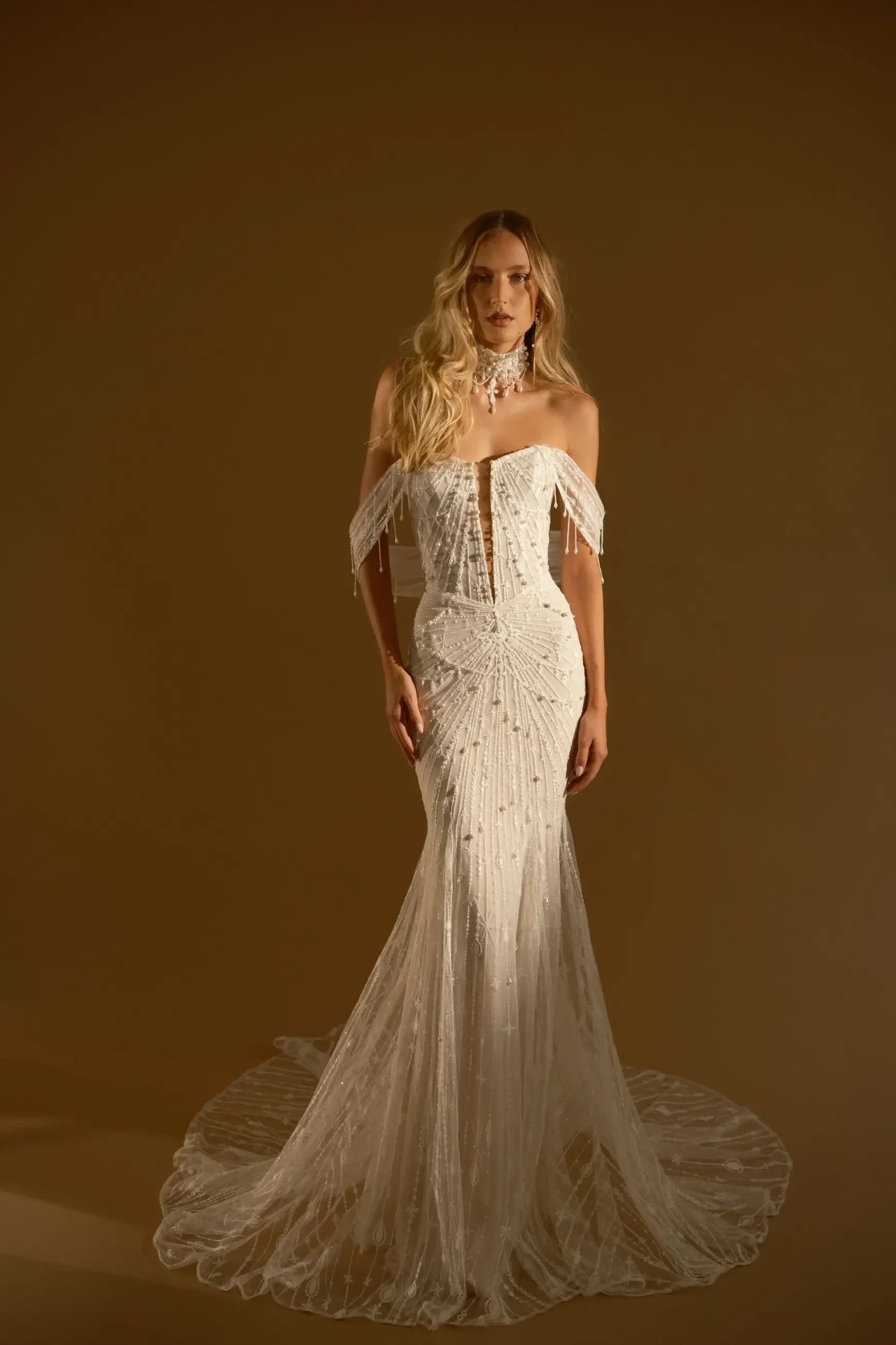 model is wearing a strapless fitted wedding dress by rish bridal