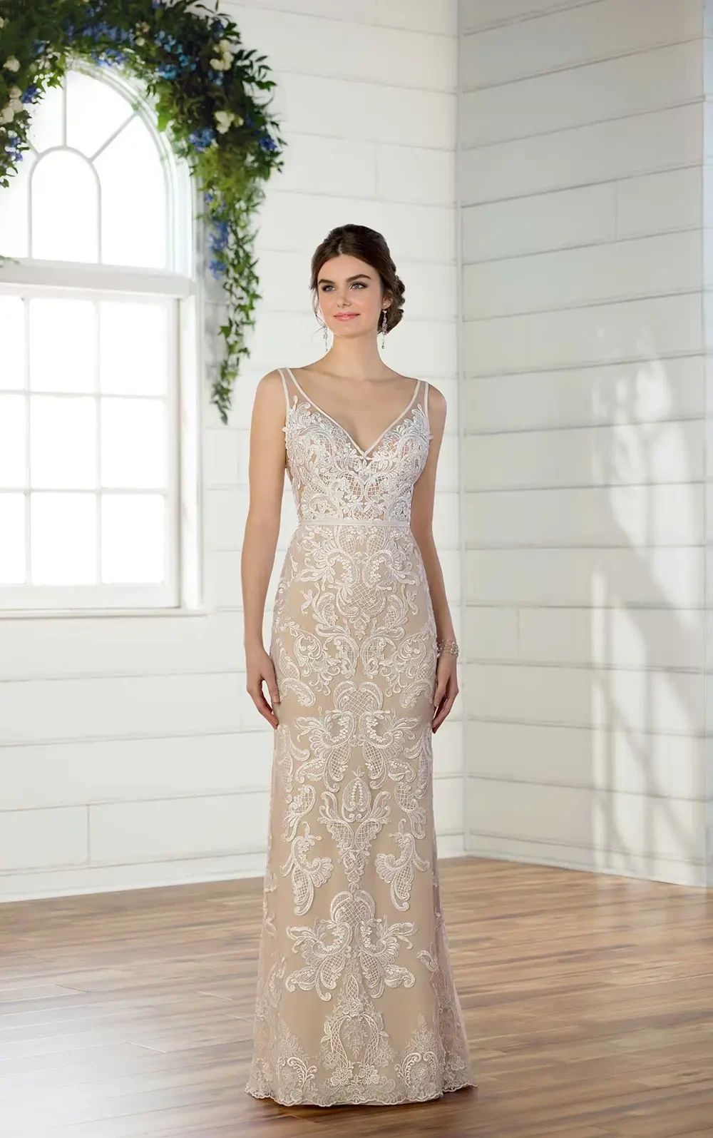 model is wearing a sleeveless open back champagne bridal gown