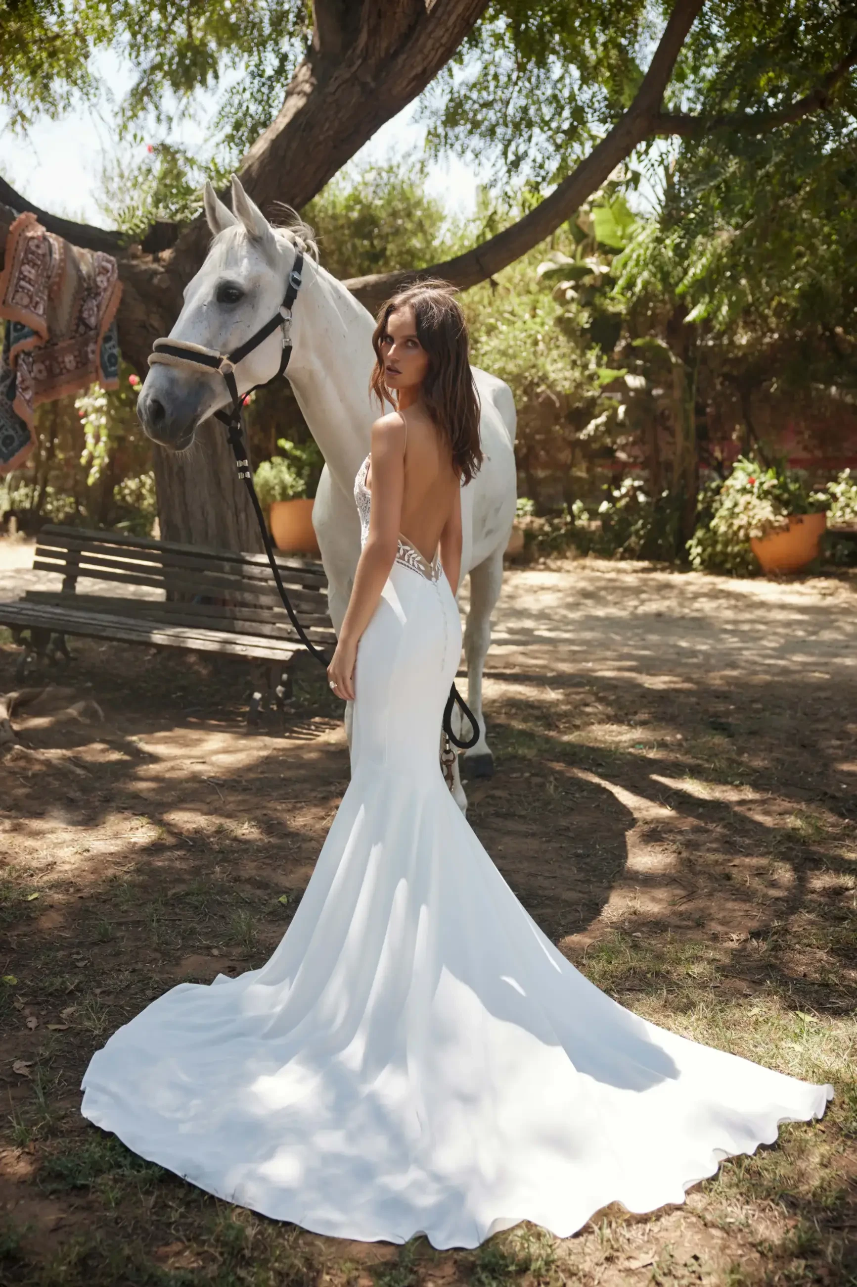 model is wearing an open back off the shoulder bridal gown by rish bridal