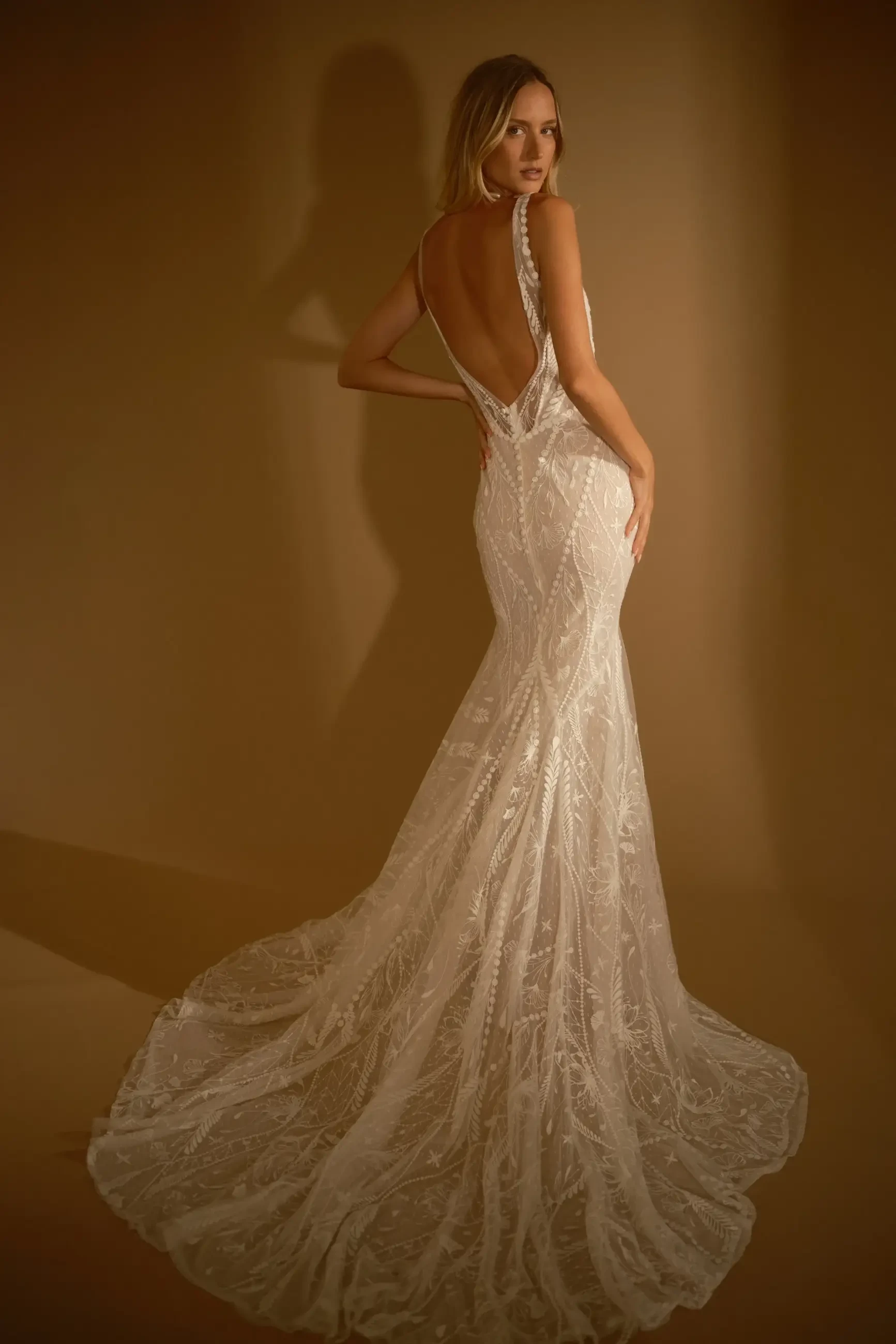 model is wearing a lace fit and flare bohemian bridal gown from rish bridal