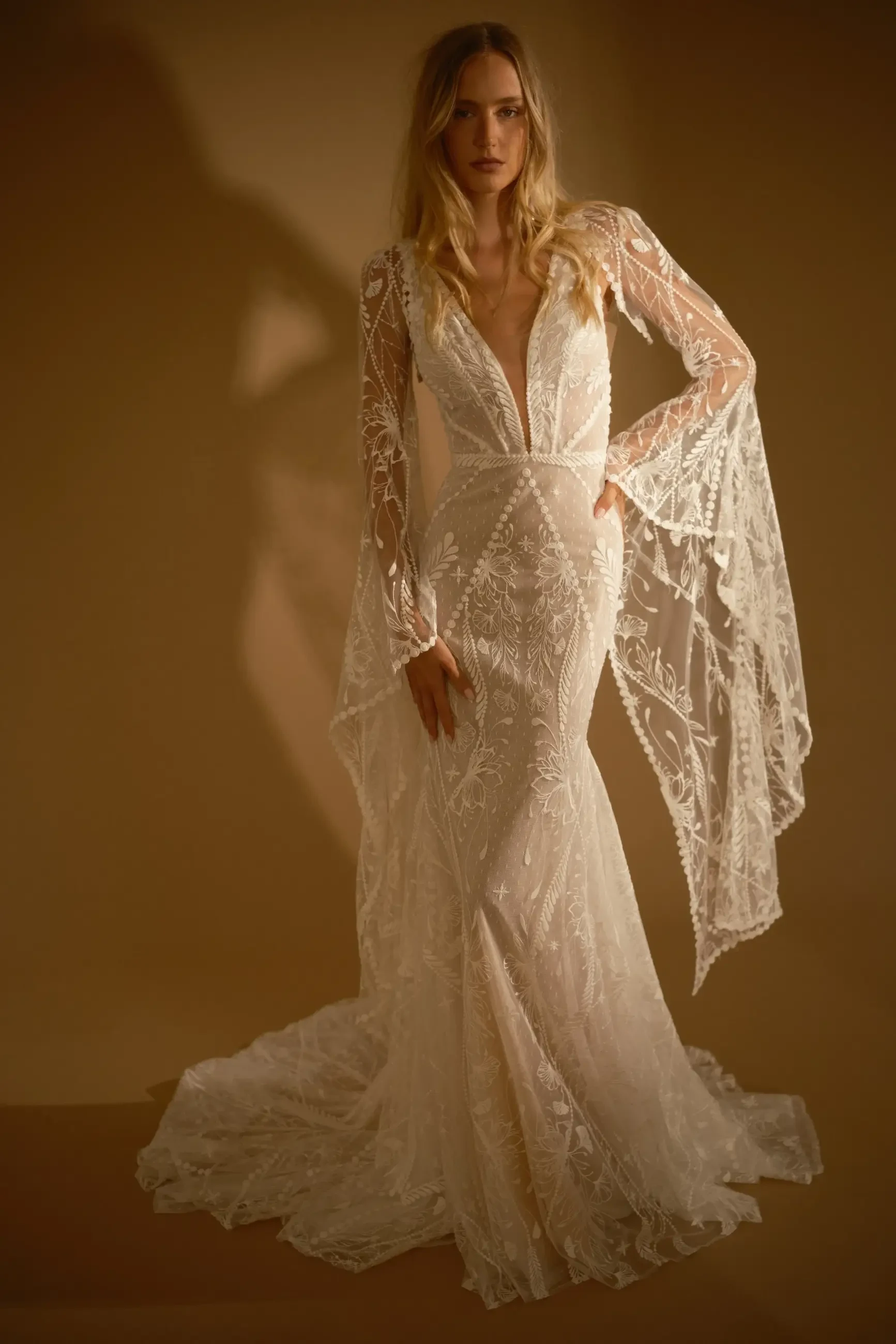 model is wearing a lace fit and flare bohemian bridal gown from rish bridal