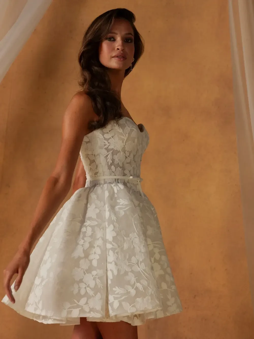 model is wearing a sleeveless mini bridal gown