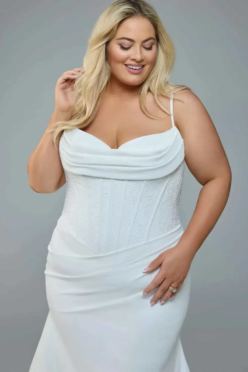 model is wearing a plus size spaghetti strap bridal gown